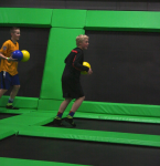Two Boys Playing Dodgeball on Trampolines